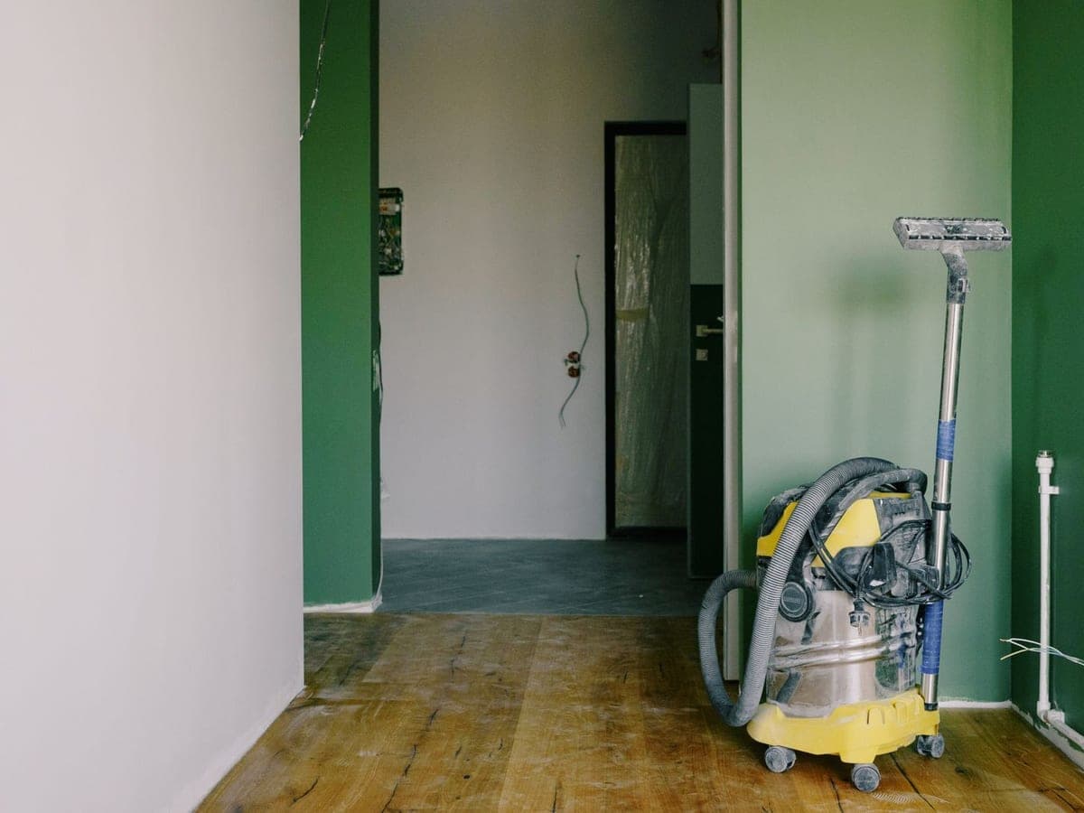 Aspirateur eau et poussière et raclette posés dans un local en cours de finition