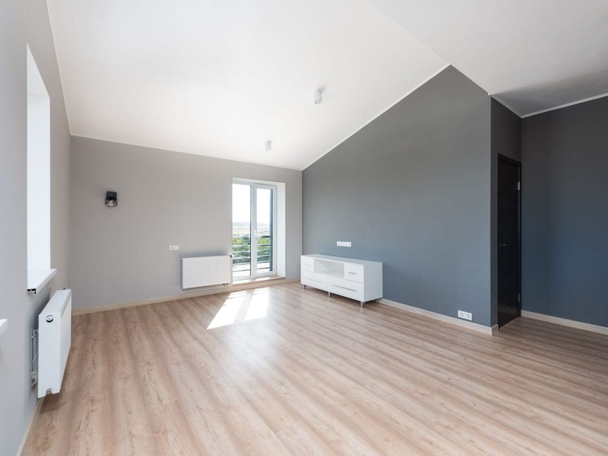 Pièce vide et lumineuse au parquet clair, prête à être remise en état